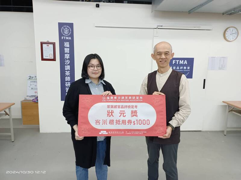 兩位茶葉感官品評班滿分學員在研習所合影，手持狀元獎狀與客茶樓抵用券，展現自我學習成果與感官訓練成就。