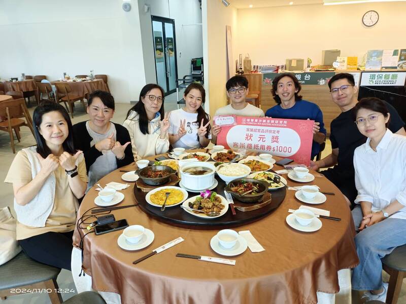 一群滿分學員在客茶樓圓桌共餐，展示茶葉感官品評課程狀元獎與抵用券，現場氣氛融洽，展現學茶過後的交流與慶賀。