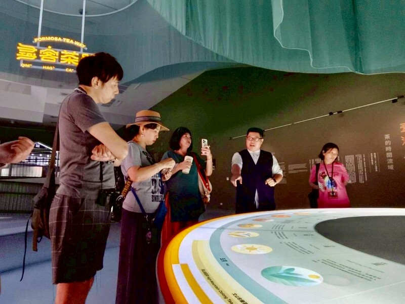 臺灣客家茶文化館主展覽區導覽體驗，講解員向訪客介紹茶文化互動展項。凡訂席客茶樓尾牙春酒專案，即贈展廳門票，當日可免費參觀館內展覽與文化體驗區。