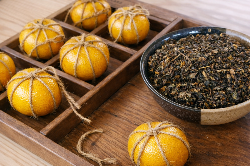 客家酸柑茶 DIY 製作過程，將茶葉填入綁繩包覆的酸柑果中，呈現傳統藏茶工藝與手作細節