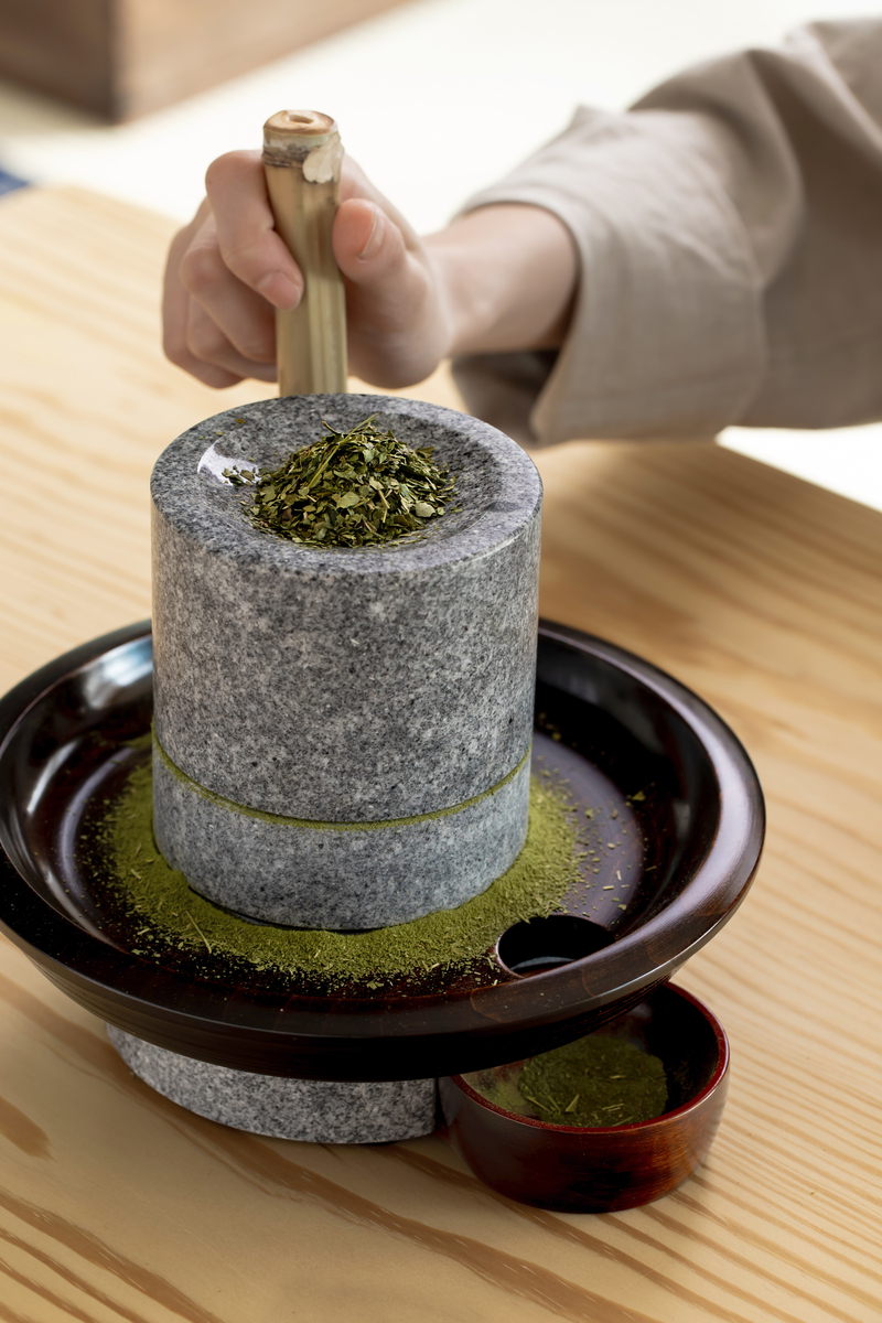 日式茶室文化體驗，展示以石磨手工研磨抹茶的過程，桌面擺有抹茶粉、茶葉罐與傳統和風茶具，場景來自福爾摩沙茶館六國茶室主題活動